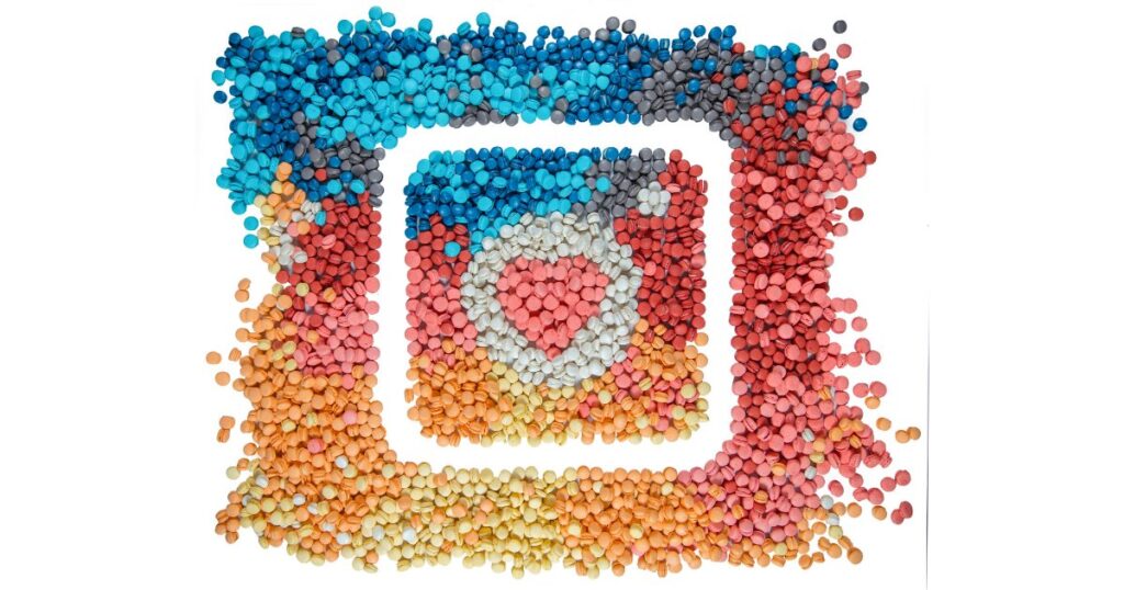 Logotipo do Instagram montado com pequenas contas coloridas em azul, vermelho, laranja e amarelo, com um coração no centro